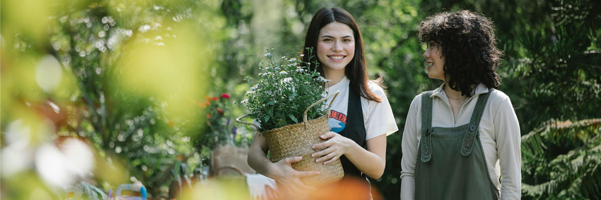 Gärtnerin mit Kunde im Gespräch in Gewächshausumgbung