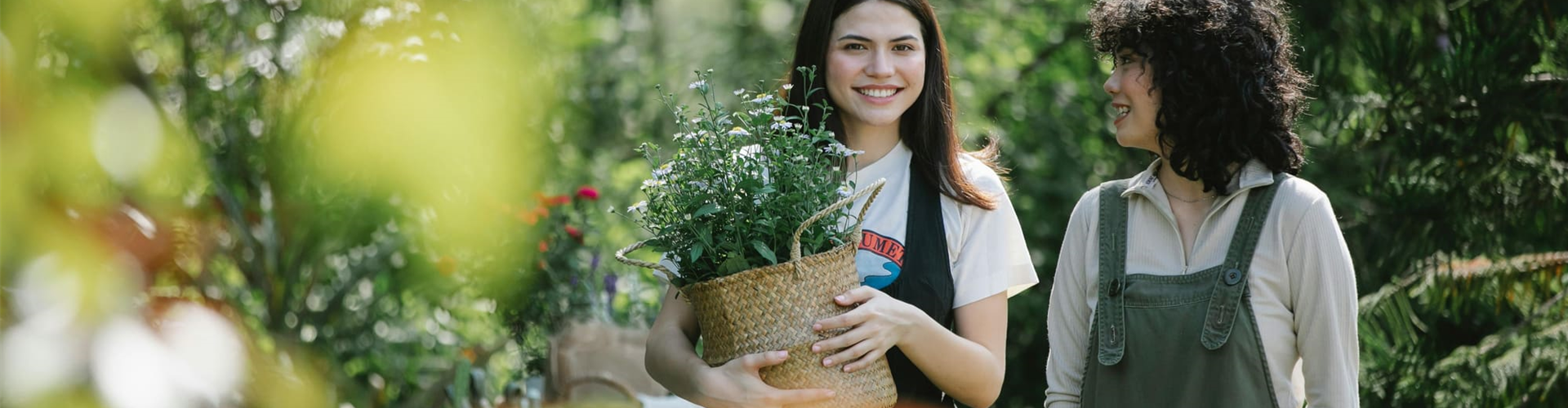 Gärtnerin mit Kunde im Gespräch in Gewächshausumgbung